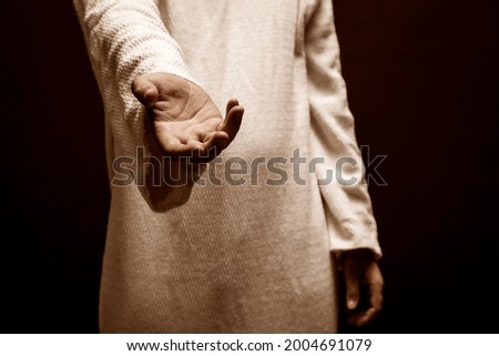 Jesus Christ praying to God with open arms in the dark black night Royalty-Free Stock Photo #2004691079