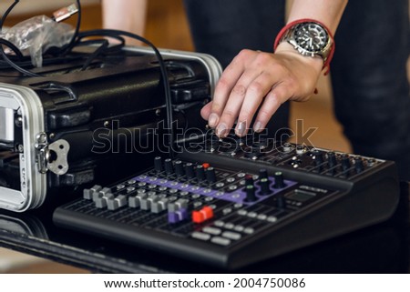 Male hands checking professional music equipment before concert