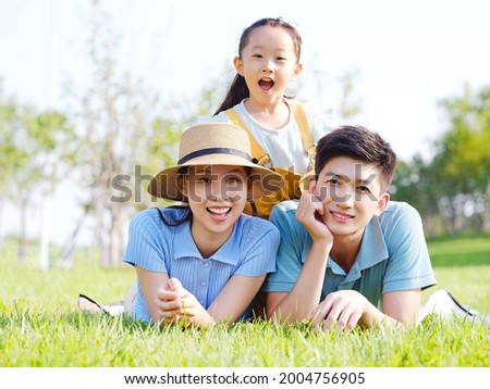Happy family of three on the grass high quality photo