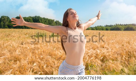 Image of a beautiful girl breathing deeply on a yellow field. The concept of purity of nature. Mixed media Royalty-Free Stock Photo #2004776198