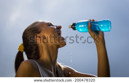 woman drinks energy drink after long run