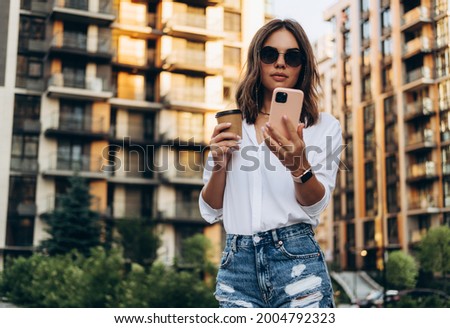 Portrait of a Successful Business woman Using iPhone 12 pro with coffee cup 