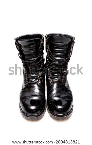 Used military boots with horizontal lacing are made of black, polished leather, used to dress up the uniform. Isolated on white background. Selective focus.
