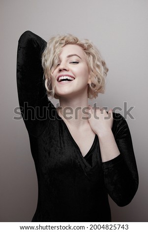 Headshot of gorgeous attractive young lady with curly hair smiling. Marilyn Monroe.