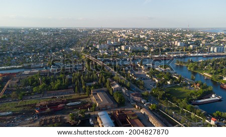 Aerial view of the Kherson city. A shipyard on the banks of the Dnieper River of which there are cranes and ships. Residential area with houses and greenery Royalty-Free Stock Photo #2004827870