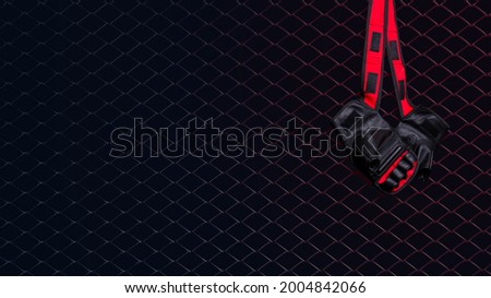 Gloves for MMA hang on nail on a black background.  Royalty-Free Stock Photo #2004842066