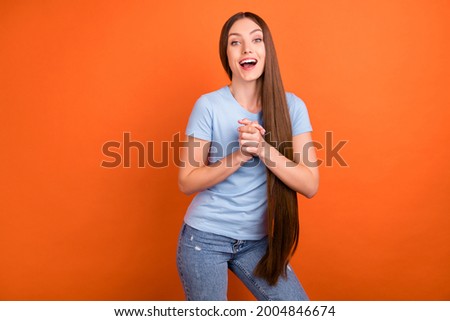 Photo of hooray straight hairdo millennial lady hold hands wear blue t-shirt isolated on vivid orange color background