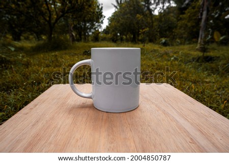 white mug on orange plantation background. Mug mockup with orange plantation view

