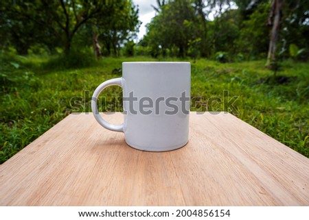 white mug on orange plantation background. Mug mockup with orange plantation view
