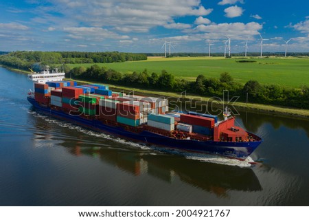  Container ship on the Kiel Canal and windmill on the background.  Royalty-Free Stock Photo #2004921767