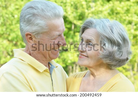 Senior couple in summer park on green background