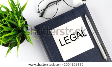 Stickers on notebook text LEGAL with pen and glasses on the white background