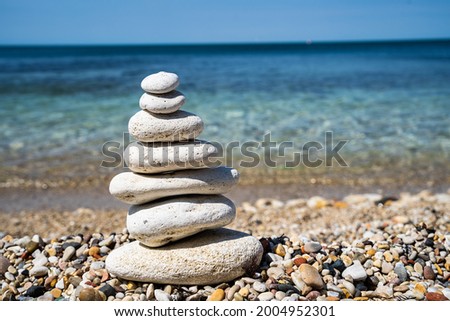 Pebble beach with balancing stone pyramid close-up. Calm and balance concept.