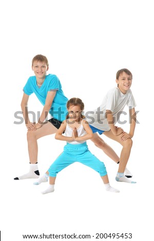 Two young boys brothers and little sister exercising isolated on white background