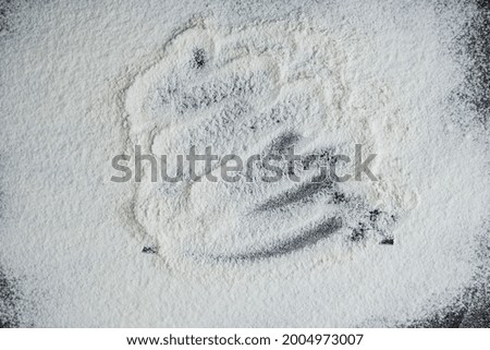 Baking background with copy space on black surface for your text. Top view. Flour on a black. Wheat flour. Bakery