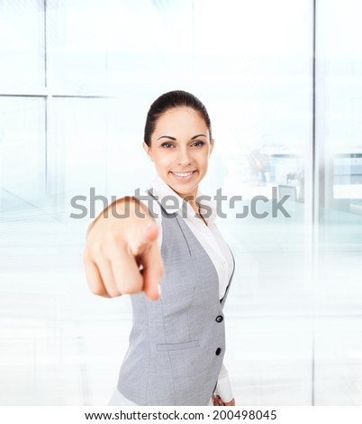 Business woman point finger at you looking at camera. businesswoman excited smile in modern office