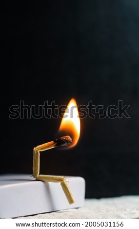 Concept of weakness, sadness, and loneliness. Image of a man-made matchstick. Burning matchstick man sitting alone without a partner. Matchstick art photography. Royalty-Free Stock Photo #2005031156
