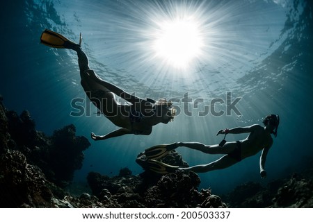 Underwater shot of the couple moving on depth over coral reef Royalty-Free Stock Photo #200503337
