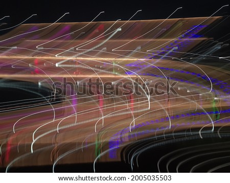 Blue, red, white and purple light painting photography, long exposure, ripples and waves against a black background. Curves and waves of neon green light against a black background.