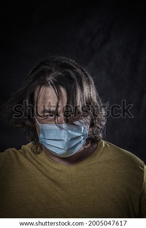 Man wearing medical mask over dark background