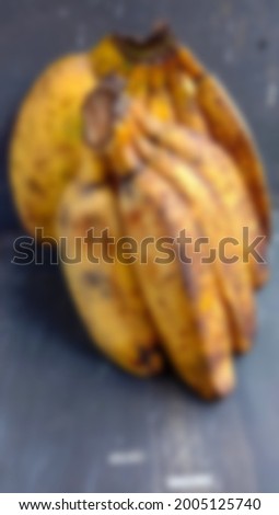Blur photo of ripe banana fruit on yellow and black background