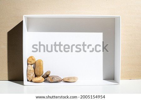 white frame with stones on the wood background