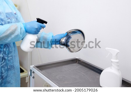 Nurse disinfecting medical instruments with sprayer in clinic. Disinfection concept Royalty-Free Stock Photo #2005179026