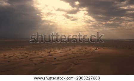 AERIAL. Sunset light shines across Great Sand Dunes at UAE. HDR dramatic sunset in desert. Royalty-Free Stock Photo #2005227683