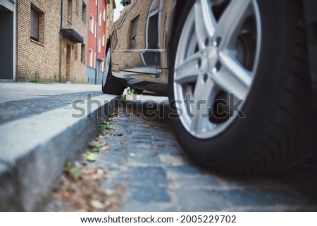 one wheel on curb, bad parking on a sidewalk Royalty-Free Stock Photo #2005229702