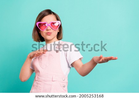 Photo of charming funny school girl wear pink overall glasses dancing empty space isolated teal color background