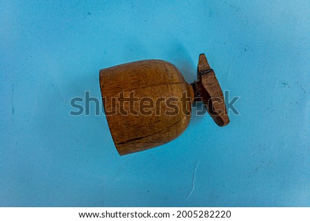overturned and broken wooden glass at the bottom of the glass isolated on blue background
