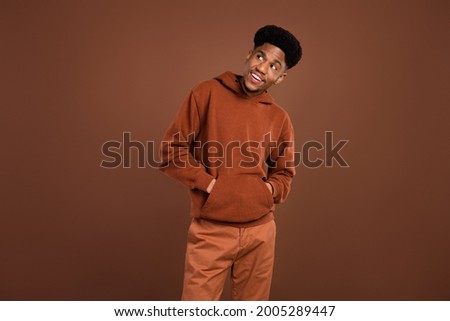 Photo of cheerful curious african guy look up empty space toothy white smile wear hoodie isolated on brown background Royalty-Free Stock Photo #2005289447