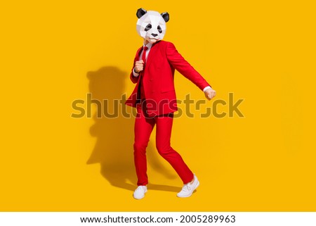 Photo of positive crazy panda guy enjoy dance wear mask red suit tie sneakers isolated on yellow color background
