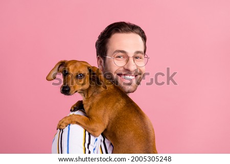 Photo of young happy cheerful positive man hold hands dog friend isolated on pastel pink color background