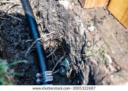 Cut sprinkler water line with repair line attached in an open trench Royalty-Free Stock Photo #2005322687