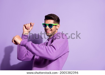 Portrait of attractive cheerful guy dancing having fun music club weekend isolated over purple violet color background