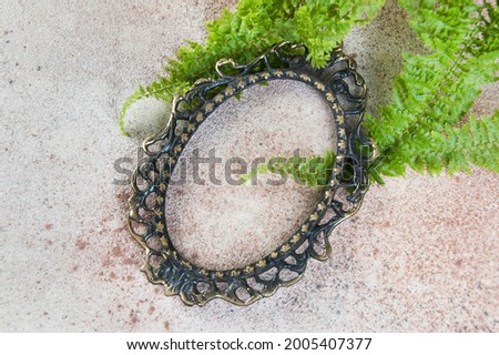 Antique bronze empty picture frame on concrete background. Photography props and copy space for text.  