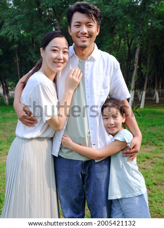 Happy family of three playing in the park high quality photo