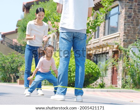A happy family of three skipping rope outdoors high quality photo