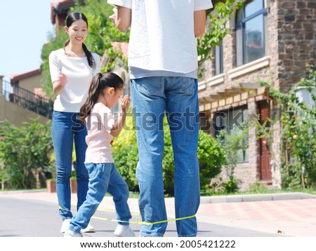 A happy family of three skipping rope outdoors high quality photo