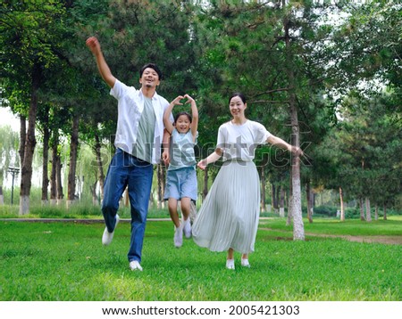 Happy family of three playing in the park high quality photo Royalty-Free Stock Photo #2005421303