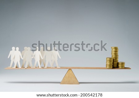 Men balanced on seesaw over a stack of coins