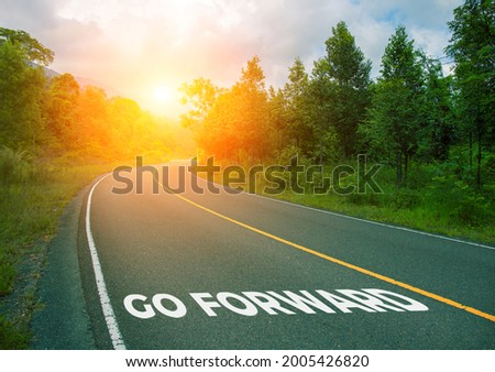 Go forward, concept photo of asphalt road. Encouraging quote on Summer forest landscape with curved highway. Inspirational quote banner. Positive motivational card. Mastermind concept cover