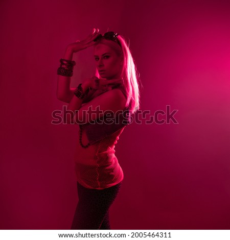 Disco style, young attractive woman in retro style outfit dancing in pink light. Night Club