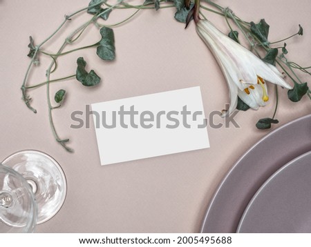 Table place mockup with green foliage and lily flower. Wedding and Birthday table setting. Overhead view.