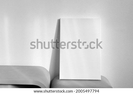 White canvas mockup on shelf on wall with shadows. Blank picture. Stretched cotton canvas