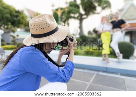 Group of women taking travel photo in Asian travel destination, concept of summer vacation in reopened international tourism business, tourism and hotel industry in post pandemic world