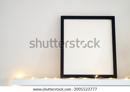 Blank wooden photo frame stands in the interior on a white background. Mockup poster frame close up in home interior. High quality photo
