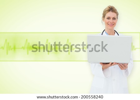 Blonde doctor using laptop against medical background with green ecg line