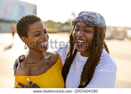 Two girlfriends embracing in the city
 Royalty-Free Stock Photo #2005604180